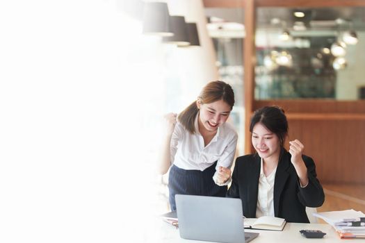 A portrait of two Asian business woman showing joy from sales of new projects that meet customer demand.