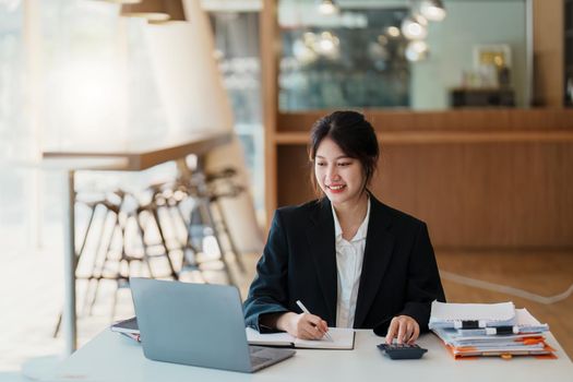 Portrait of an Asian businesswoman working with a happy smile in the office.