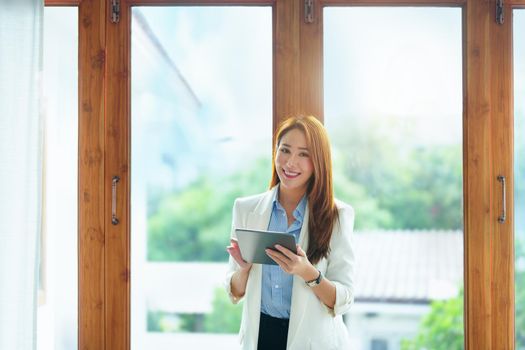 Portrait of an Asian businesswoman holding a computer tablet.