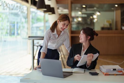 A portrait of two young Asian businesswoman plan marketing strategies and investments to profit from their clients.