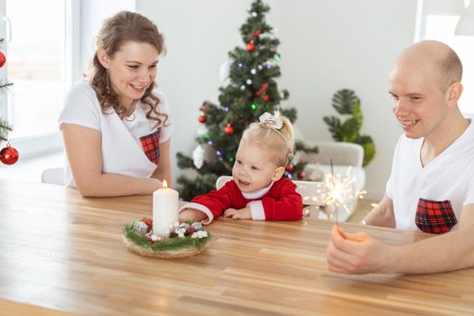 Baby child with hearing aid and cochlear implant having fun with parents in christmas room. Deaf and health