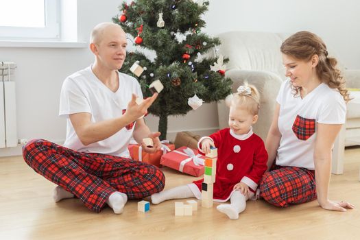 Baby child with hearing aid and cochlear implant having fun with parents in christmas room. Deaf and health