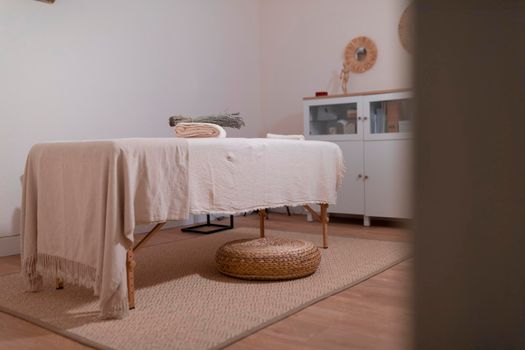 Empty massage room with a quiet atmosphere and tone, ready to receive the clients that seek for their wellness