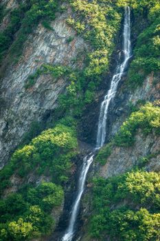 Unnamed waterfall alongside the more famous Bridal Veil Falls down cliffs of Keystone Canyon outside Valdez in Alaska