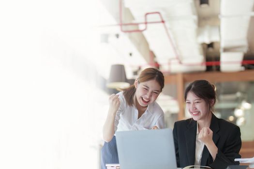 A portrait of two Asian business woman showing joy from sales of new projects that meet customer demand.