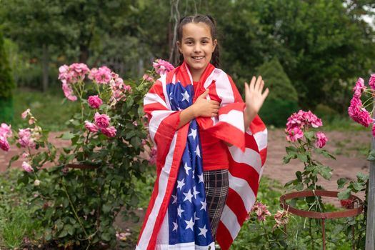 Patriotic holiday. Happy kid, cute little child girl with American flag. USA celebrate 4th of July. High quality photo