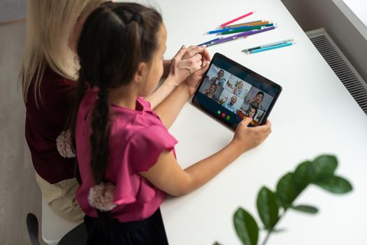 mother and daughter using digital tablet for online chatting from home.