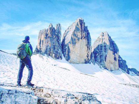 Backpacker on trip aound  Tre Cime di Lavaredo in sunny April  morning. View from tour around popular massive, Dolomite Alps,  Italy