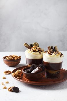 Delicious chocolate trifle or pudding with whipped cream in a glass on a gray background. copy space