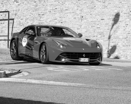 URBINO, ITALY - JUN 16 - 2022 : FERRARI TRIBUTE Ferrari F12 Berlinetta IN an old racing car in rally Mille Miglia 2022