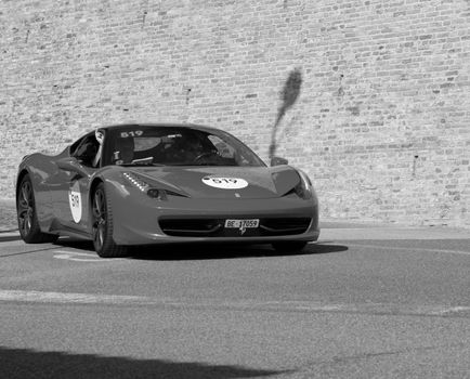 URBINO, ITALY - JUN 16 - 2022 : FERRARI TRIBUTE Ferrari 458 Italia IN an old racing car in rally Mille Miglia 2022