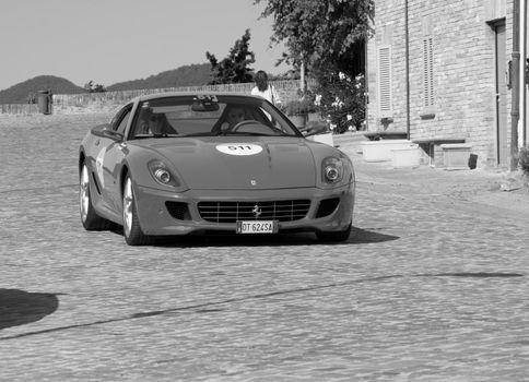 URBINO, ITALY - JUN 16 - 2022 : FERRARI TRIBUTE Ferrari 599 Gtb Fiorano IN an old racing car in rally Mille Miglia 2022