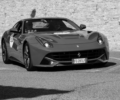 URBINO, ITALY - JUN 16 - 2022 : FERRARI TRIBUTE Ferrari F12 Berlinetta IN an old racing car in rally Mille Miglia 2022