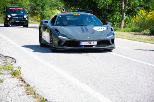 URBINO, ITALY - JUN 16 - 2022 : FERRARI TRIBUTE Ferrari F8 Tributo IN an old racing car in rally Mille Miglia 2022