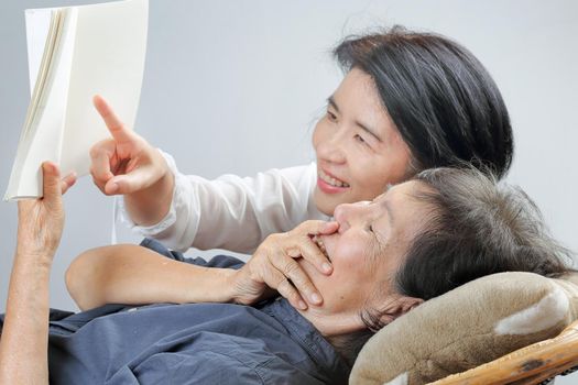 elderly woman reading fable book with daughter