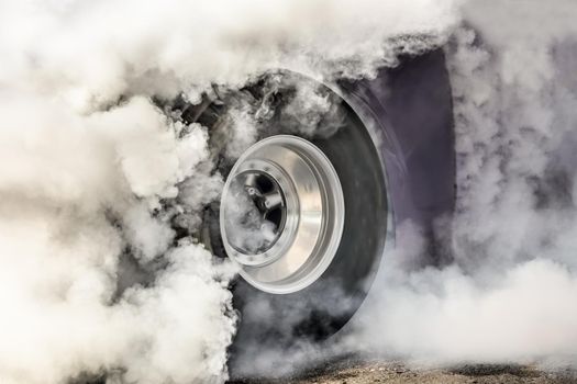 Drag racing car burns rubber off its tires in preparation for the race