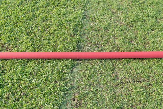 industrial hose in lawn of sport field.