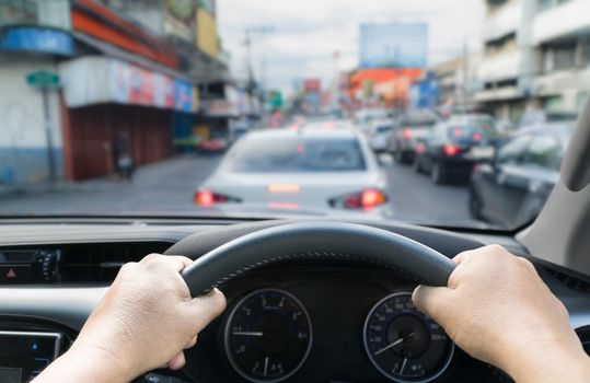 Hands holding steering car in the traffic jam ,Thailand