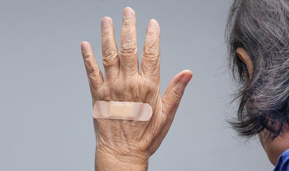 Elderly woman adhesive bandage on her hand