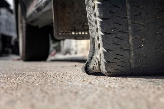 burst car tire on street in town.