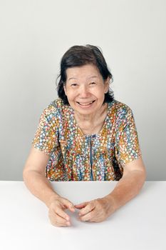 smiling elderly woman ,sitting on white background