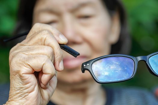 Elderly asian woman repair broken glasses