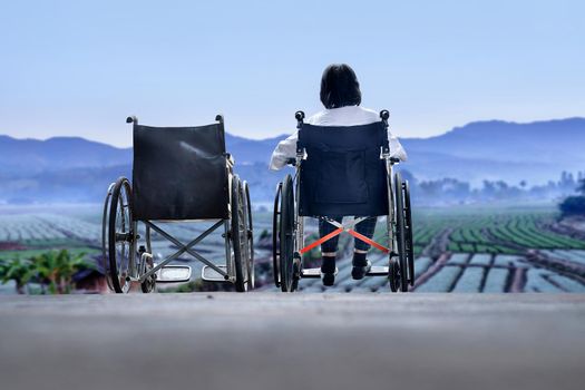 Elderly woman with empty wheelchair standing together