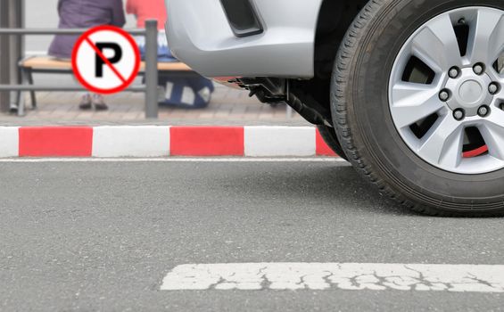 illegally parked car at red stripes sign on street