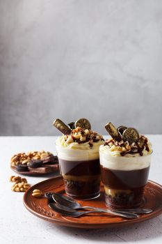 Delicious chocolate trifle or pudding with whipped cream in a glass on a gray background. copy space