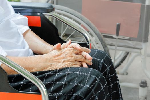 Elderly woman hand while waiting on wheelchair