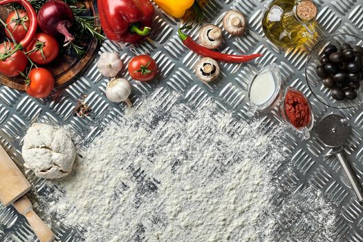 Ingredients and dough for making pizzas with an overhead view on freshly mixed mounds of pastry, a jar of olive oil and pot of tomato sauce, overhead view on metal background. Top view. Flat lay. Still life