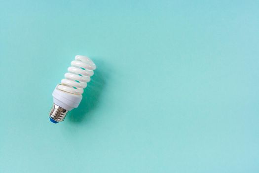 Energy saving light bulb on a blue background. Economical consumption of electricity. The concept of nature conservation