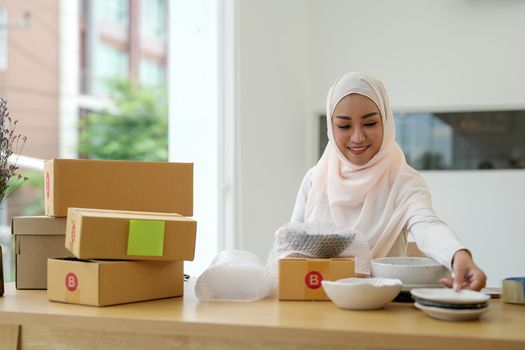 SME freelance woman muslim working with packaging startup entrepreneur small business owner at home,Online business seller packaging and delivery concept