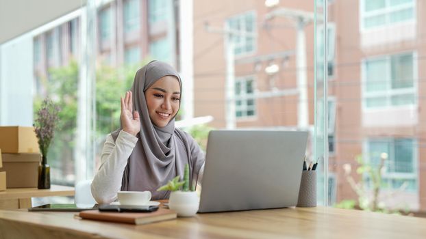 Young smiling beautiful muslim woman relaxing using laptop computer working and video conference meeting at home.work from home concept