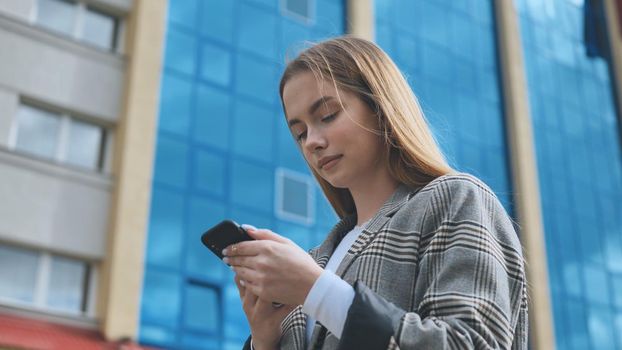 A girl walks through town and looks at her smartphone