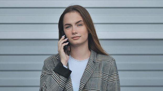 A student girl in a blazer talking on the phone