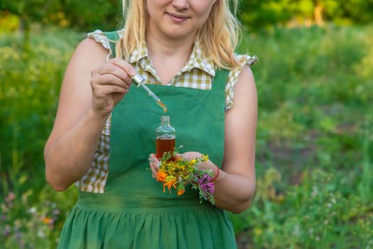 A woman makes herbal tincture. Selective focus. Nature.