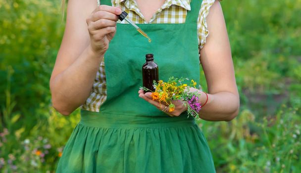 A woman makes herbal tincture. Selective focus. Nature.