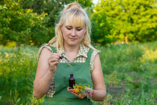 A woman makes herbal tincture. Selective focus. Nature.