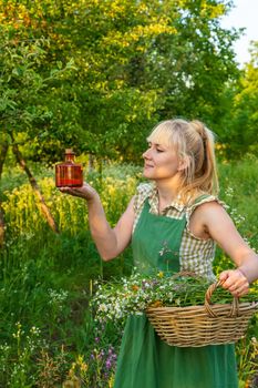 A woman makes herbal tincture. Selective focus. Nature.