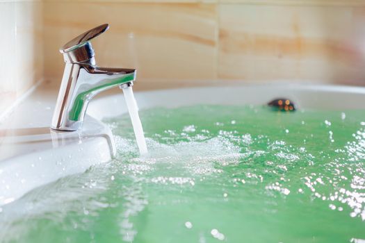 single handle faucet pouring hot water in a bath tub