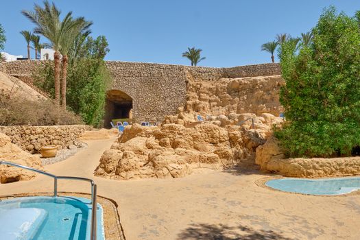 Beautiful recreation area with mini pools, palm trees and green plants.