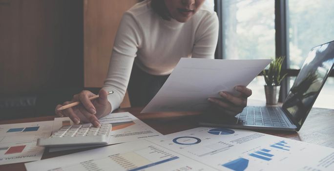 Closeup of female who are using their fingers to press the calculator for calculating bills in the office.finance report. Business office concept..