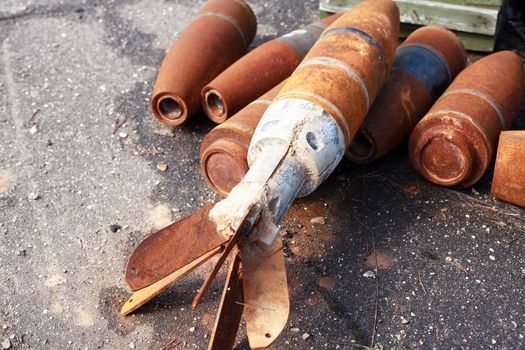 Waste of war. Few rusty used missiles on gray asphalt background