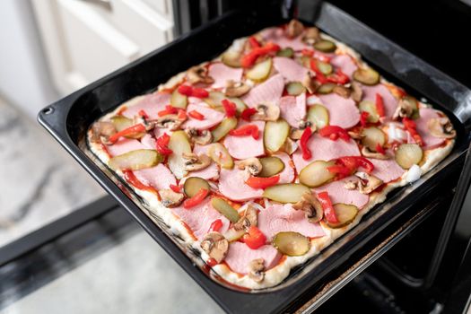 homemade open pie with sausage, pickles and a mushrooms