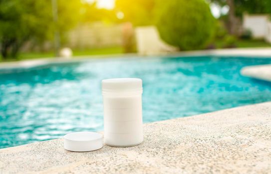 Chlorine tablets for swimming pool cleaning and maintenance, Chlorine tablets kit in the edge of a swimming pool, chlorine tablets for swimming pool disinfection