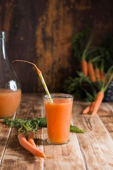 freshly squeezed carrot juice, and raw carrots, vegetarian vegetable vitamin drink, vintage still life concept, fresh carrot juice on wooden background, rustic still life