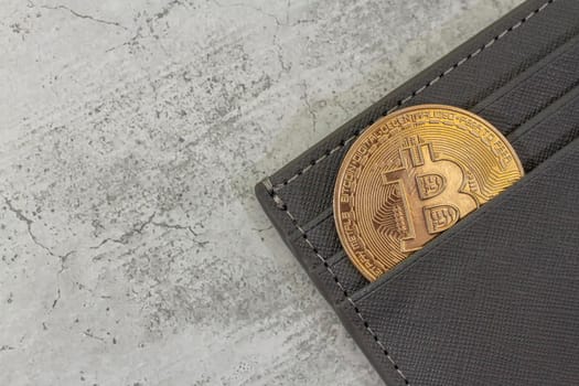 bitcoin gold coin place in wallet on concrete background. Online payment technology, digital wallet, computer financial, digital blockchain, bitcoin stock, cryptocurrency trading and mining investment concept.