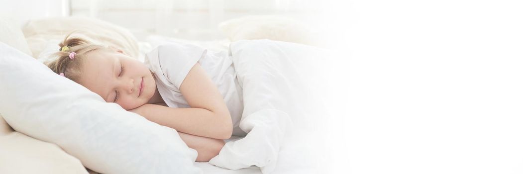 A cute little girl enjoys an afternoon nap in bed after dinner. Web banner.