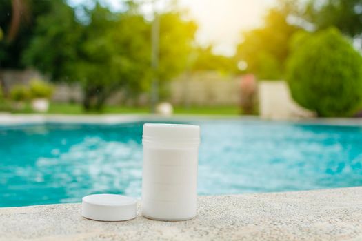 Chlorine tablets kit in the edge of a swimming pool, chlorine tablets for swimming pool disinfection, Chlorine tablets for swimming pool cleaning and maintenance, 